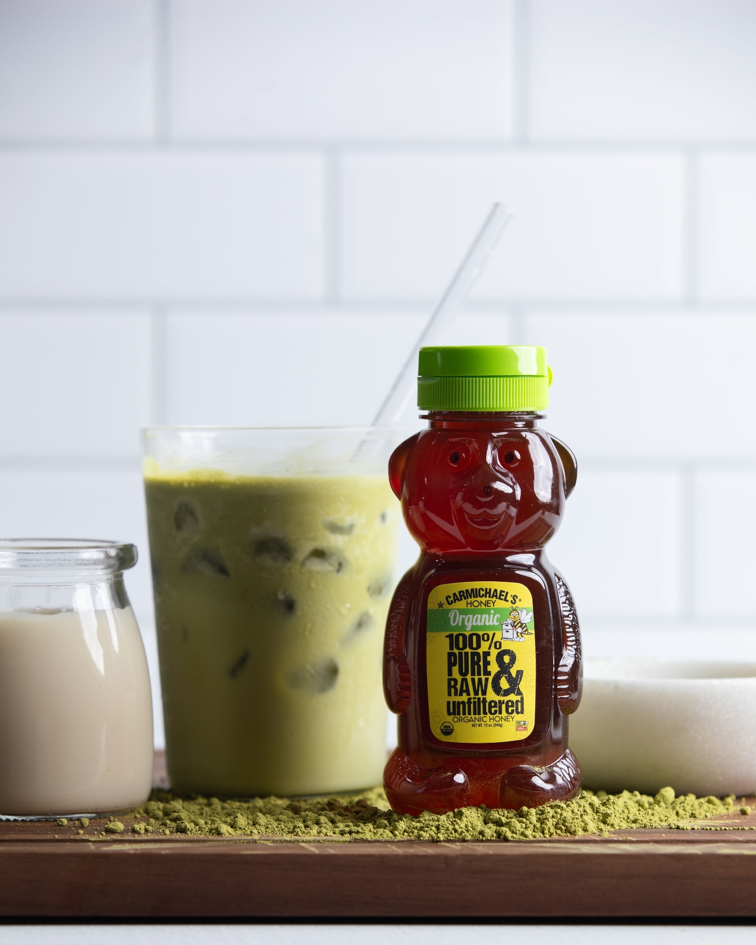 Honey bear bottle beside iced matcha